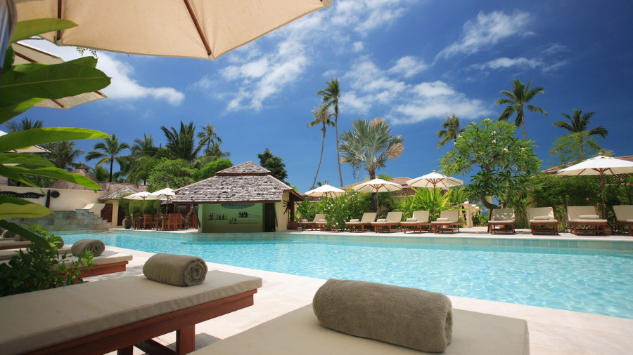 View of resort with pool and lounge chairs, evaluated by our timeshare cancellation company near San Antonio, Texas.