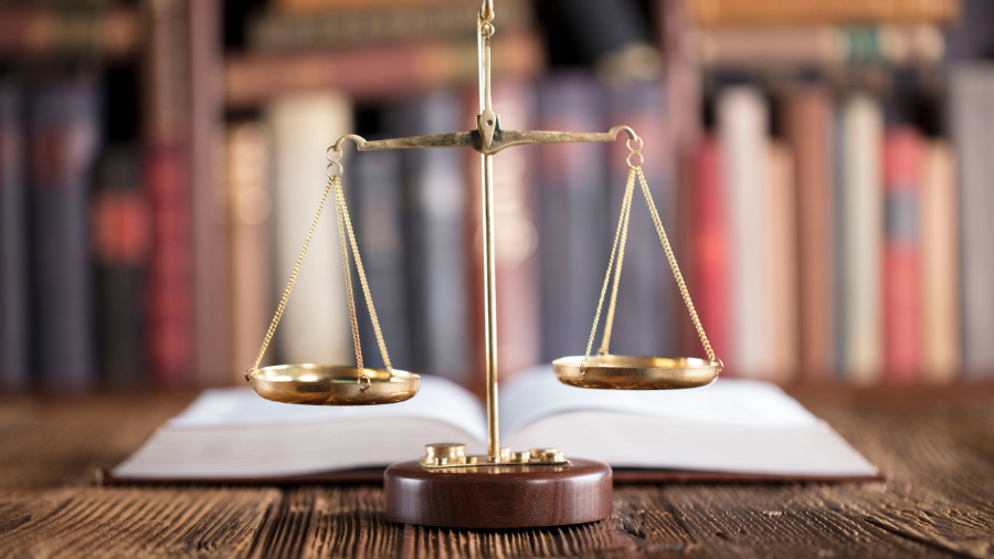 Scales of Justice in front of books, symbolic of our timeshare cancellation services near St. Louis, MO.